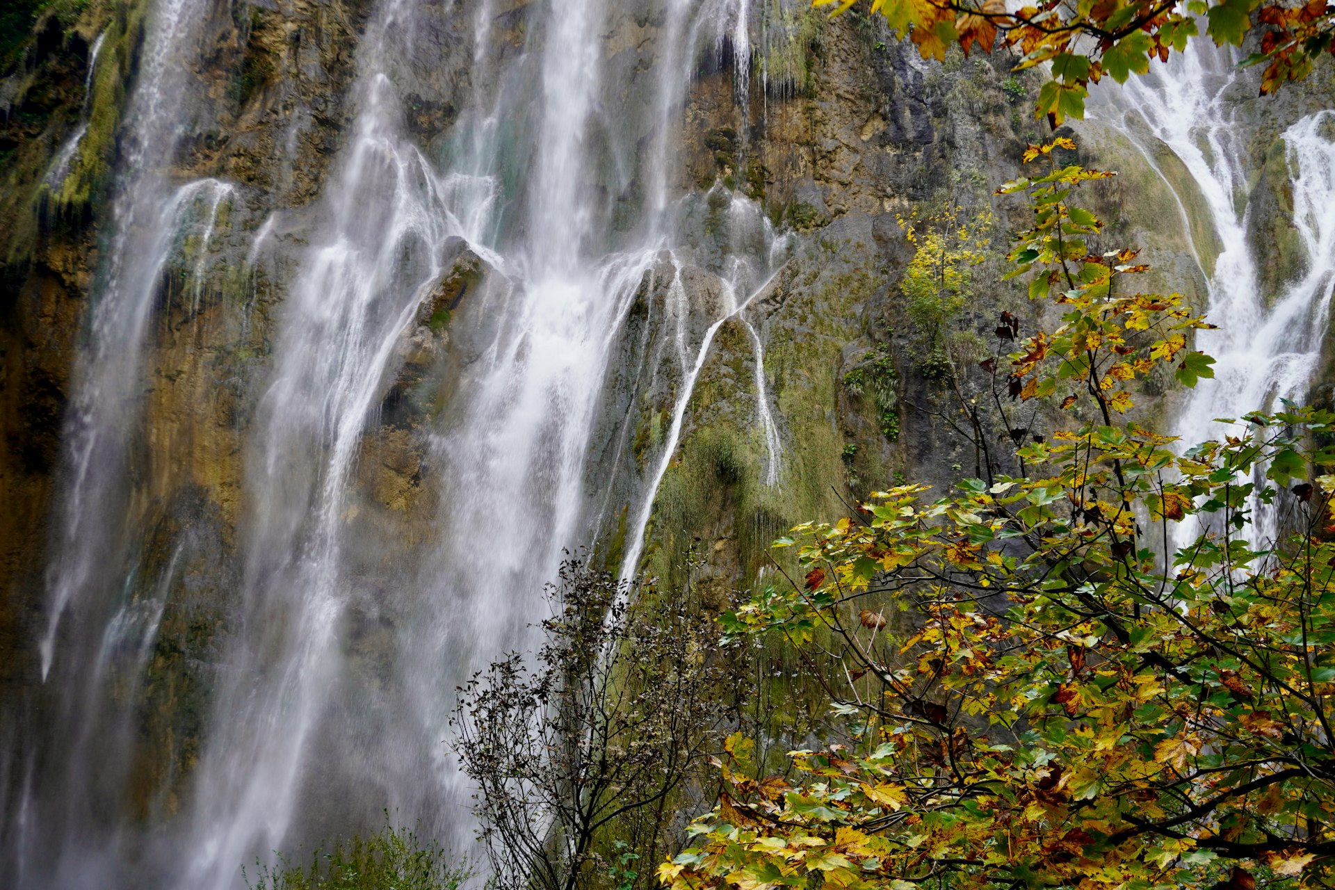 Group of visitors viewing waterfall at Plitvice Lakes in autumn